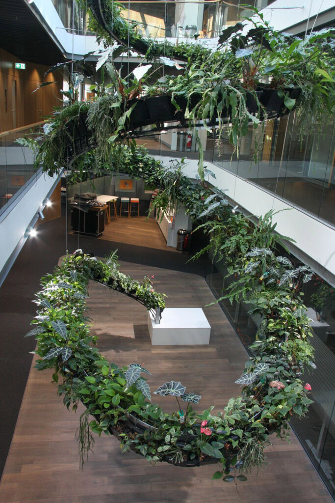 Die „Spiral Hanging Gardens“, ein Projekt von aplantis und Sumser Raumbegrünung, ziehen sich mit üppigem Blattwerk über drei Etagen. Bildnachweis: Sumser Raumbegrünung